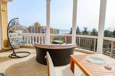 a large balcony with a table and a swing at Barbie-Themed 3BDR Penthouse Near The Beach, Nessebar in Nesebar