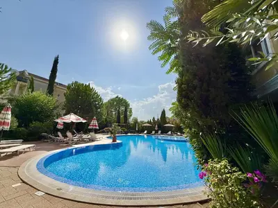 a large swimming pool with chairs and umbrellas at Messembria Palace - Menada Apartments in Sunny Beach