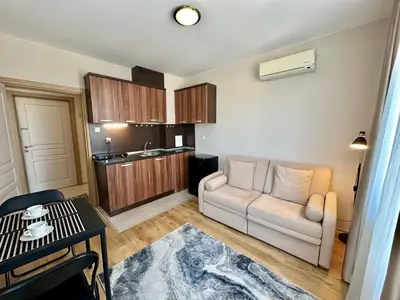 a living room with a couch and a kitchen at Messembria Palace - Menada Apartments in Sunny Beach