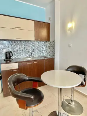 a kitchen with a white table and two black chairs at Carina Beach - Private apartment - BSR - 3 in Sunny Beach