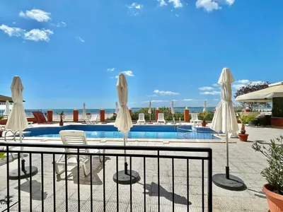 a pool with white umbrellas and chairs next to a fence at Carina Beach - Private apartment - BSR - 3 in Sunny Beach