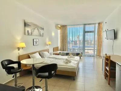 a hotel room with a bed and a table and chairs at Carina Beach - Private apartment - BSR - 3 in Sunny Beach