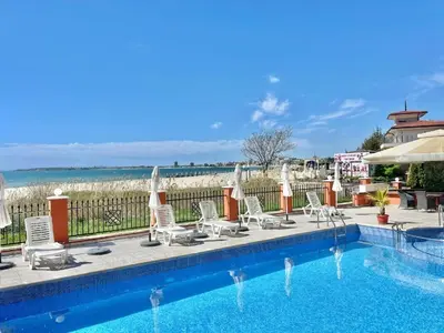 a pool with chairs and umbrellas next to the ocean at Carina Beach - Private apartment - BSR - 3 in Sunny Beach