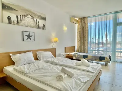 a bedroom with two beds and a large window at Carina Beach - Private apartment - BSR - 3 in Sunny Beach