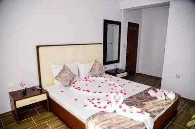 a bedroom with a large bed with red flowers on it at Къща за гости Силвия in Shkorpilovtsi