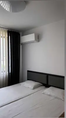 a bedroom with a white bed with a window at The better apartment in Burgas City