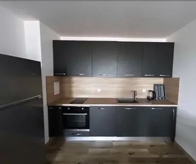 a kitchen with black cabinets and a sink at The better apartment in Burgas City
