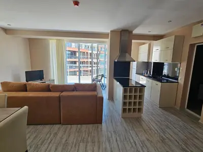 a living room with a couch and a kitchen at Sineva Apartments in Ravda
