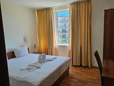 a bedroom with a bed and a large window at Sineva Apartments in Ravda