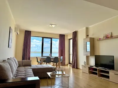 a living room with a couch and a television and a table at Cosher Gardenia Palace Apt 6 Free Parking in Pomorie