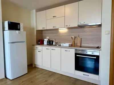 a kitchen with white cabinets and a white refrigerator at Cosher Gardenia Palace Apt 6 Free Parking in Pomorie