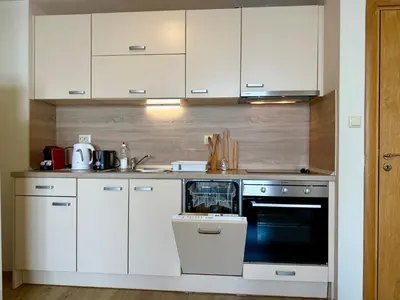a kitchen with white cabinets and an oven at Cosher Gardenia Palace Apt 6 Free Parking in Pomorie
