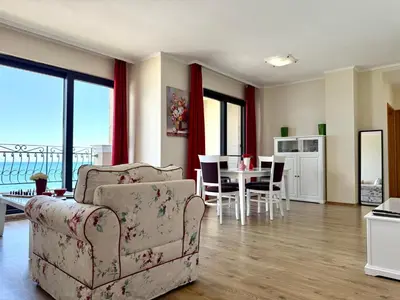 a living room with a couch and a table with chairs at Cosher - Gardenia Palace Apt 10 Free Parking in Pomorie