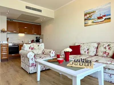 a living room with a couch and a table with chess at Cosher - Gardenia Palace Apt 10 Free Parking in Pomorie