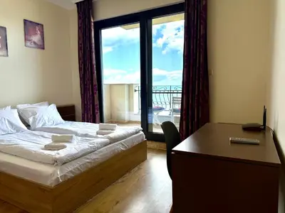 a bedroom with a bed and a desk and a window at Cosher - Gardenia Palace Apt 9 Free Parking in Pomorie