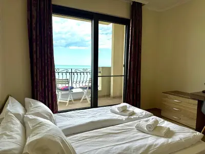 a bedroom with a bed and a large window with a balcony at Cosher - Gardenia Palace Apt 9 Free Parking in Pomorie