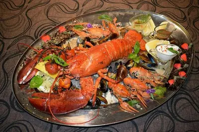 a plate of lobster and other foods on a table at Cosher - Gardenia Palace Apt 9 Free Parking in Pomorie