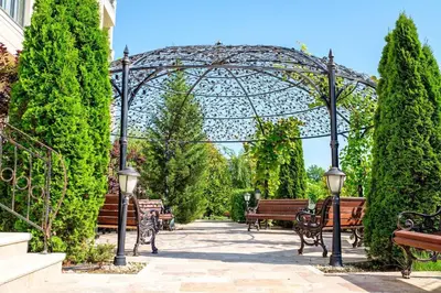 a group of benches in a garden with a gazebo at Cosher - Gardenia Palace Apt 11 Free Parking in Pomorie