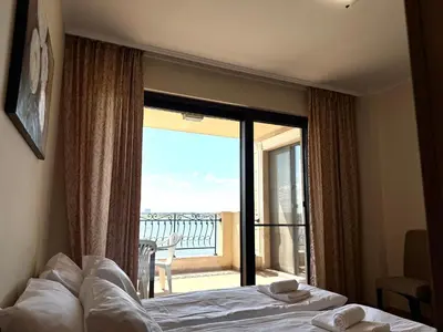 a bedroom with a bed and a view of a balcony at Cosher - Gardenia Palace Apt 11 Free Parking in Pomorie