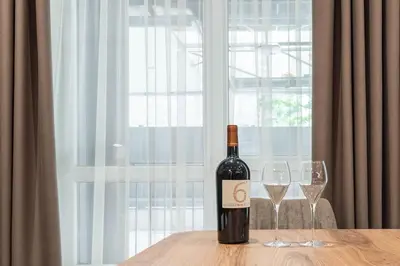 a bottle of wine sitting on a table with two glasses at City Center Luxury Studio in Varna City