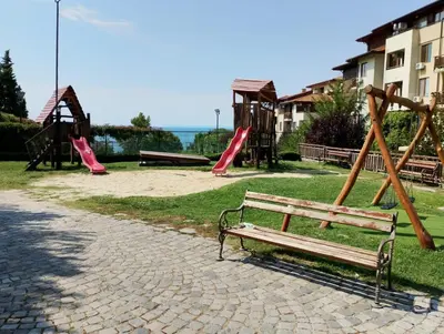 a park with a bench and slides and a playground at Garden of Eden - Panorama C2 in Sveti Vlas