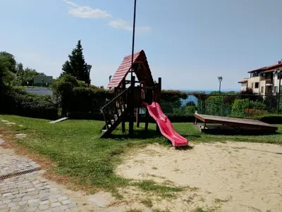 a small playground with a slide and a bench at Garden of Eden - Panorama C2 in Sveti Vlas