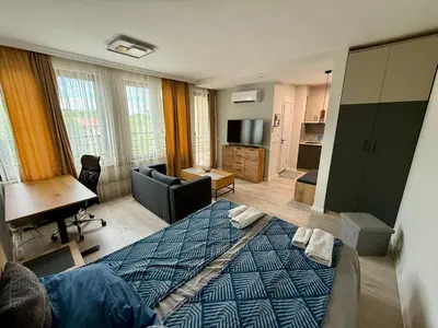 a bedroom with a bed and a living room at Work and Relax Studio in Green Life Beach Resort in Sozopol
