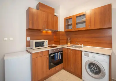 a kitchen with a washing machine and a microwave at Stylish Holiday Apartments in Karolina in Sunny Beach