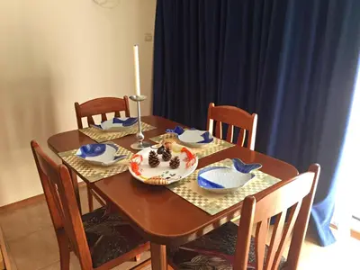 a dining room table with a candle and blue dishes on it at Family Apartments Elit1 in Sunny Beach