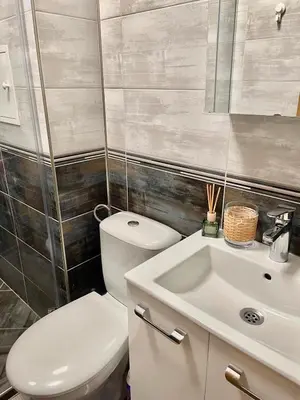 a bathroom with a white toilet and a sink at Deluxe studio beach Lazur in Burgas City