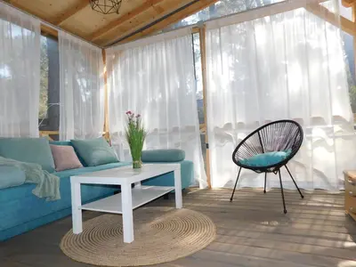 a living room with a couch and a table and a chair at The magical place in Chernomorets