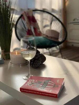 a book and a glass of wine on a table at The magical place in Chernomorets