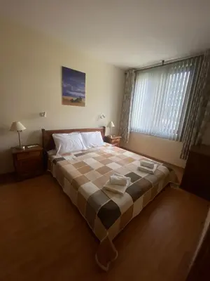 a bedroom with a large bed with a checkered blanket at Lavish, Poolside 2 Bed Apt at Garden of Eden in Sveti Vlas