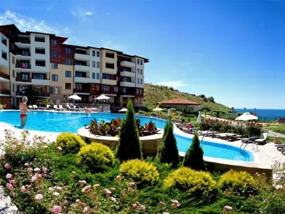 a resort with a large swimming pool next to the ocean at Lavish, Poolside 2 Bed Apt at Garden of Eden in Sveti Vlas