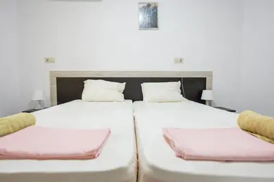 two beds with white sheets and pink pillows at Marea in Pomorie