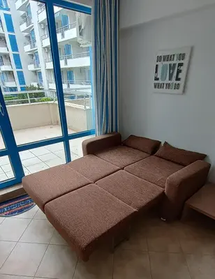 a couch in a room with a large window at Excelsior Prince ApartHotel in Sunny Beach