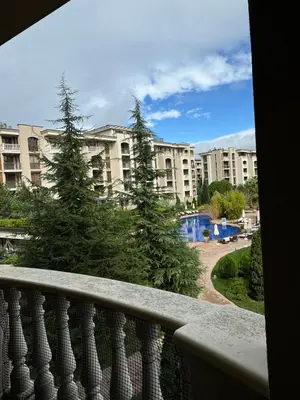 a balcony with two christmas trees in front of a building at Cascadas one-bedroom apartment with a living room in Sunny Beach