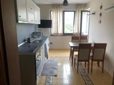 a kitchen with a sink and a table with chairs at Nesebar New Town Apartment in Nesebar