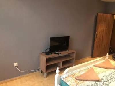 a bedroom with a bed and a television on a table at Nesebar New Town Apartment in Nesebar