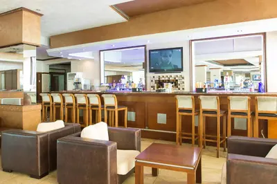 a bar with a bunch of chairs and a counter at Grenada Complex All Inclusive in Sunny Beach