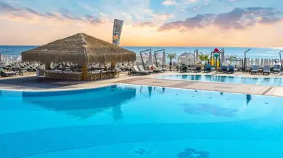 a resort with a large swimming pool and a beach at Oasis Premium Studio in Lozenets