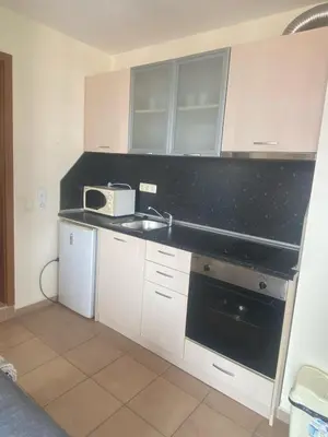 a kitchen with a sink and a microwave at 2 Bed Suite with Pool Views in Sunny Beach