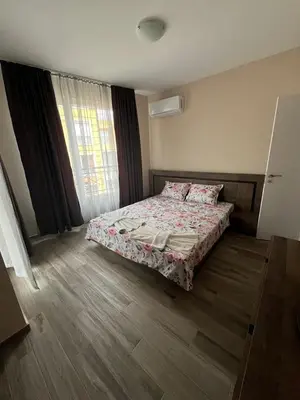 a bedroom with a bed and a window at Апартамент Габи 1 in Burgas City