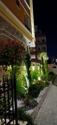 a garden in front of a building at night at Апартамент Габи 1 in Burgas City