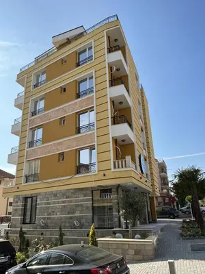 a yellow building with a car parked in front of it at Апартамент Габи 1 in Burgas City