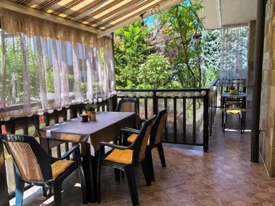 a patio with tables and chairs on a balcony at Stela Apartment in Santa Marina Holiday in Sozopol