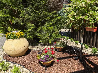 a garden with pots of flowers and a fence at Stela Apartment in Santa Marina Holiday in Sozopol
