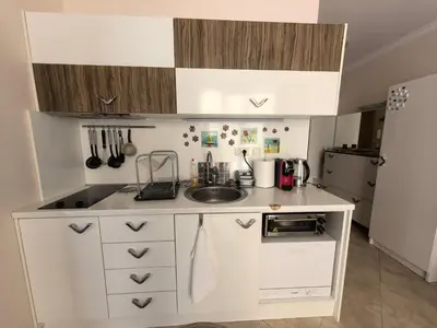 a small kitchen with white cabinets and a sink at Stela Apartment in Santa Marina Holiday in Sozopol