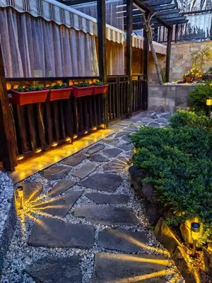 a stone walkway in a garden with a fence at Stela Apartment in Santa Marina Holiday in Sozopol
