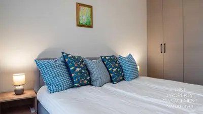 a bedroom with a bed with blue pillows at Sea-breeze retreat Zerini in Burgas City